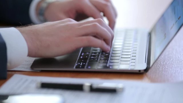 Male hands typing on laptop keyboard