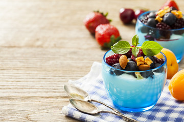 Yogurt with fruits on wooden table