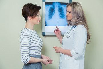 doctor explaining diagnosis to her female patient analysing x-ray photography