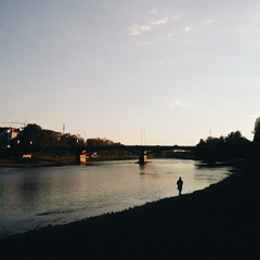 man walks along the coast of the river
