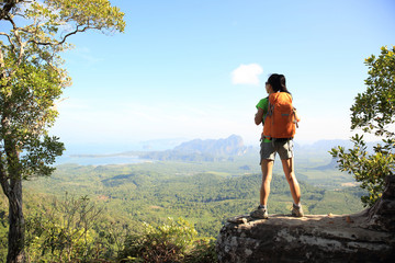 successful woman hiker enjoy the view on mountain top