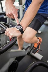 Obraz na płótnie Canvas Man using smart watch while exercising