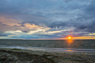 Seascape, sunrise, the sun breaks through the clouds