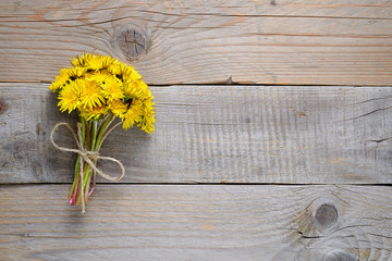 Bouquet of dandelion flowers on wooden background