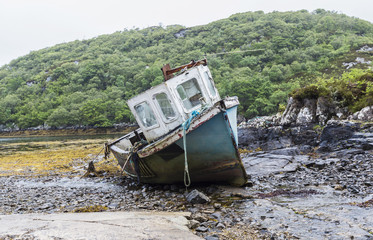Fototapeta na wymiar Sunk tug boat on the shoreline of a beautiful tropical island