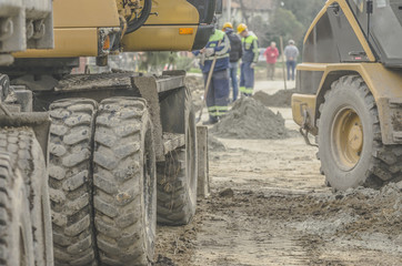 Fototapeta na wymiar Machinery at a construction site with workers in the background