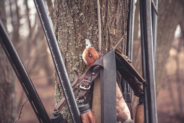 Fusils de chasse suspendus à un arbre avec des proies après une chasse au canard réussie