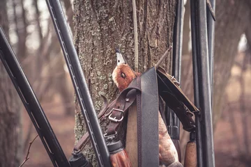 Papier Peint photo autocollant Chasser Fusils de chasse suspendus à un arbre avec des proies après une chasse au canard réussie