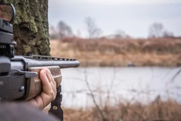 Photo sur Plexiglas Chasser Main tenant le fusil de chasse visant et prêt à tirer pendant la chasse avec espace de copie