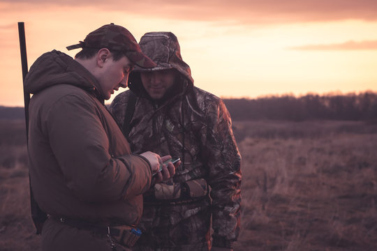 Hunters spot their position via smartphone in rual field during hunting season 