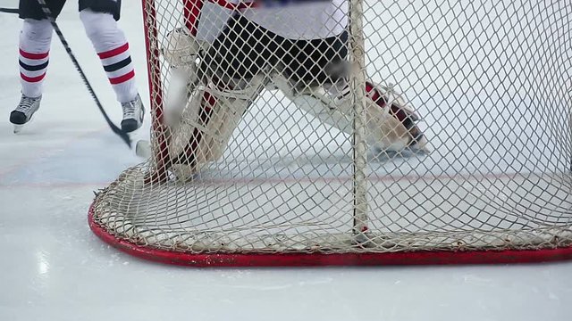 Goaltender preventing puck from entering team's net, repulsing rival attack