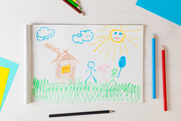 Child draws a pencil drawing of the house and his family.