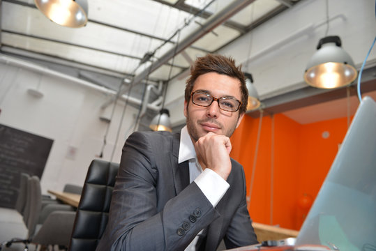Portrait of smiling Businessman posing  in coworking office