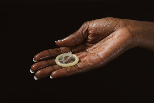 main femme noire tenant préservatif