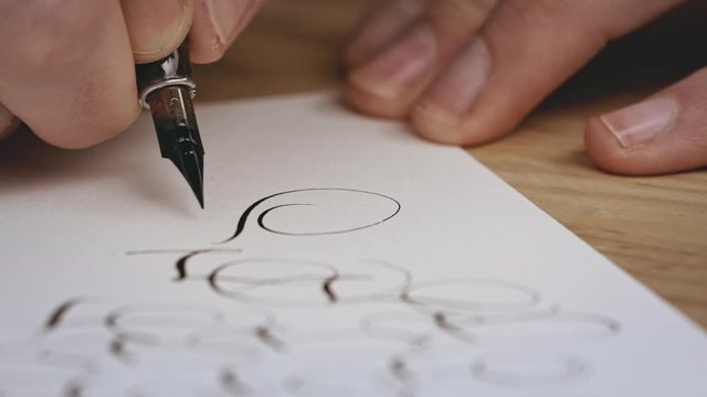 Writting letter with a pen. Calligraphy lesson. Close up. Slow motion