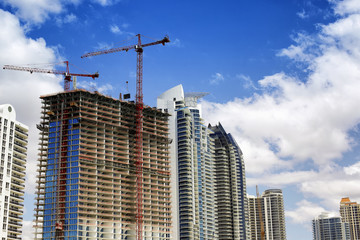 Fototapeta na wymiar Buildings with cranes on top
