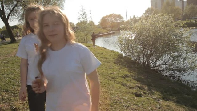 сестры близнецы гуляют по парку и едят мороженое