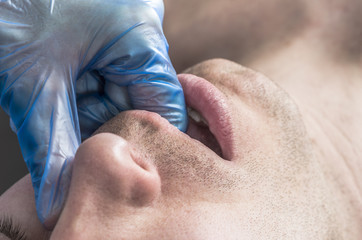 Naklejka premium Physiotherapist is doing intraoral technique of massage masseter