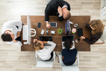 Tired Businesspeople Sleeping At Desk