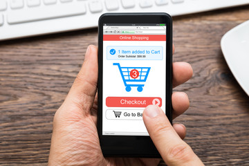 Close-up Of A Person's Hand Shopping Online On Mobile Phone