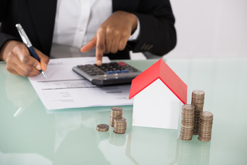 Businesswoman Calculating Invoice On Desk