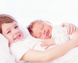 Fototapeta na wymiar portrait of cute happy siblings. young boy holding his infant br