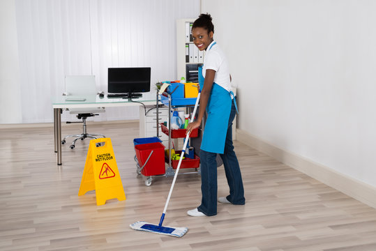 Female Janitor Mopping Floor In Office