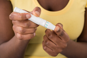 Woman Checking Blood Sugar Level With Glucometer