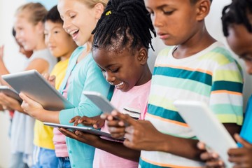 Close up view of pupils standing using tablet pc