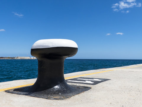 Bitt, poller, bollard at a harbor pier.