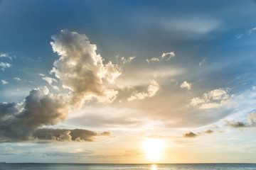 Naklejka na ściany i meble sunset on the sea with cloudy sky background