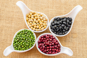 Multicolored beans in white ceramics spoon.
