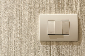 Closeup of lighting switch on concrete texture wall.
