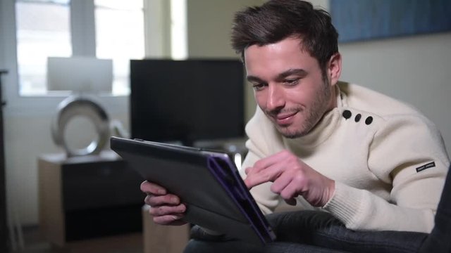 Caucasian man using digital tablet on sofa