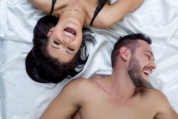 Top view of loving couple laughing in bed