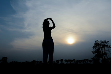 silhouette women show hands sunset background.