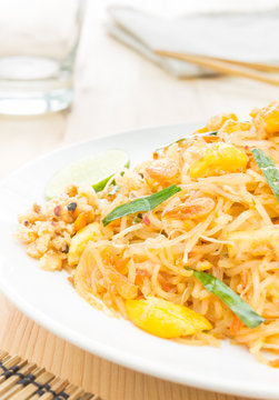 Pad Thai or Thai Fried Noodle on Wood Table with Glass Napkin Ch