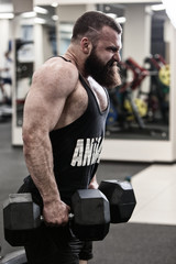 Photo Bodybuilder  working out in the gym weights