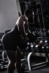 Fototapeta na wymiar Photo Bodybuilder working out in the gym weights