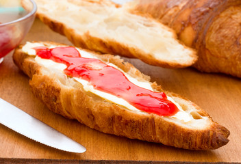 croissant smeared in butter and jam