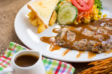 Beef steak with black pepper sauce , salad and French fries on s
