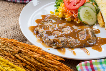Beef steak with black pepper sauce , salad and French fries on s