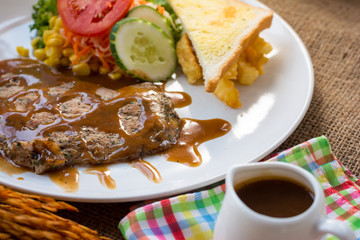 Beef steak with black pepper sauce , salad and French fries on s