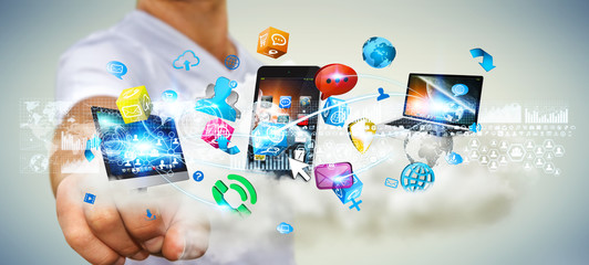 Businessman holding tech devices and icons applications over a c © sdecoret
