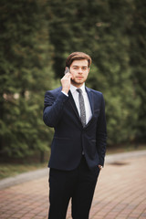 Stylish young businessman talking on the phone outdoors