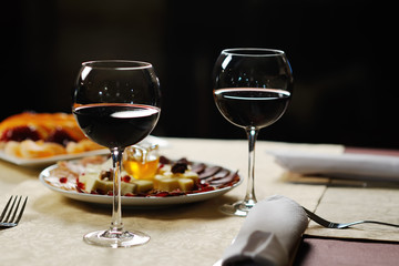 two glasses of red wine on the background of the dishes in the r