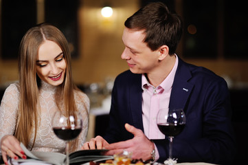 guy with a girl in a restaurant choose dishes from the menu