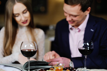 guy with a girl in a restaurant choose dishes from the menu