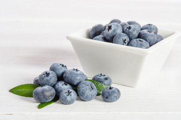 blueberries in a porcelain  cup  and on wooden background