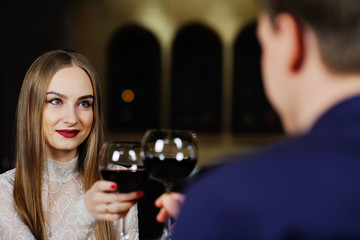 a man with a woman drinking red wine in a restaurant